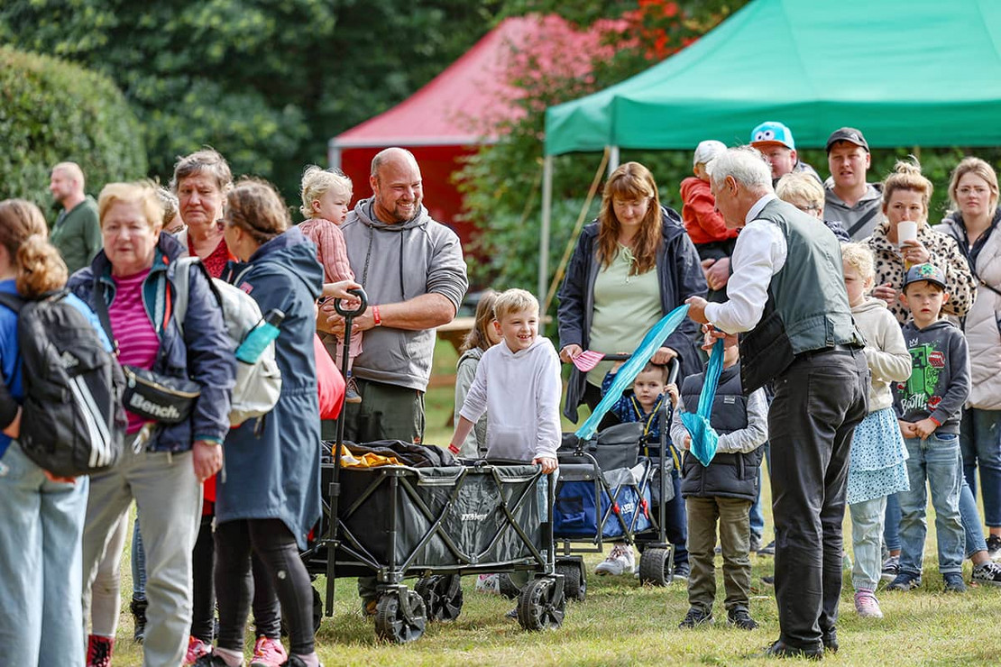 Damit das Warten nicht zu langweilig wird: Ein Zauberer unterhält die Menschen in der Schlange