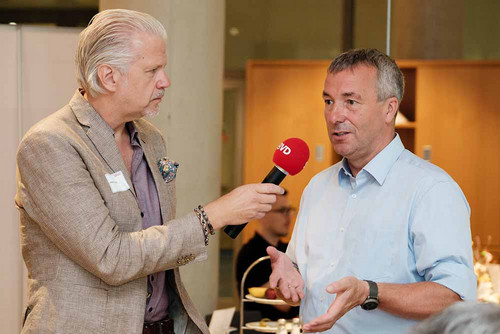 Ein Mann hält einem anderen das Mikrofon hin. 