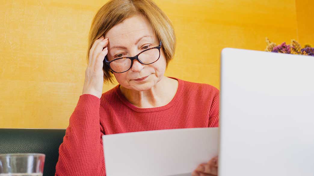 Frau liest mit besorgtem Gesicht einen Zettel.